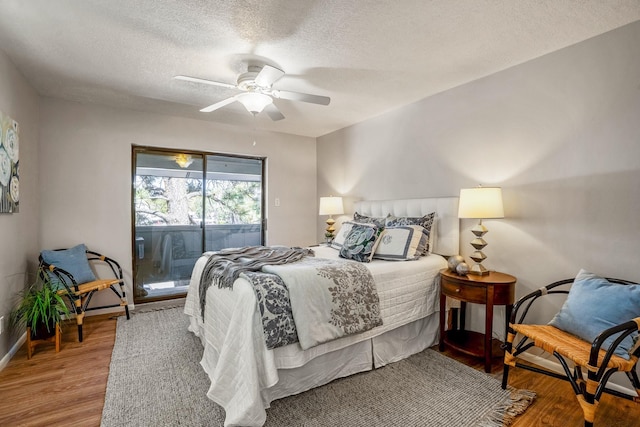 bedroom featuring a textured ceiling, access to exterior, wood finished floors, and ceiling fan