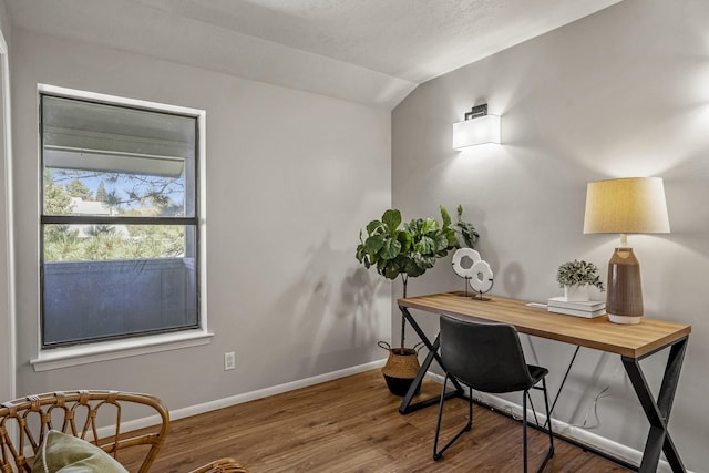 office space with baseboards, wood finished floors, and vaulted ceiling