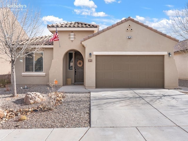 mediterranean / spanish-style house with concrete driveway, a tiled roof, an attached garage, and stucco siding