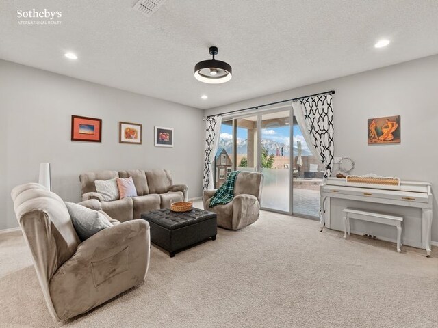 living room featuring visible vents, baseboards, carpet, recessed lighting, and a textured ceiling