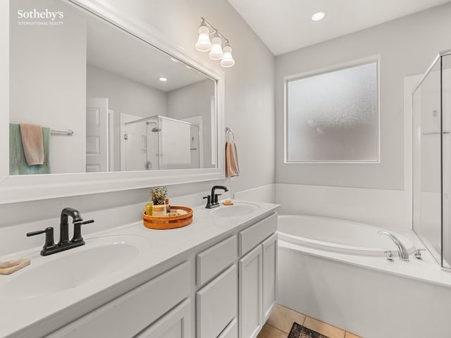 full bath featuring a sink, a garden tub, a shower stall, and tile patterned flooring