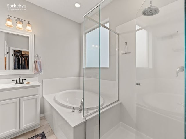 full bathroom featuring vanity, a bath, a stall shower, and tile patterned flooring