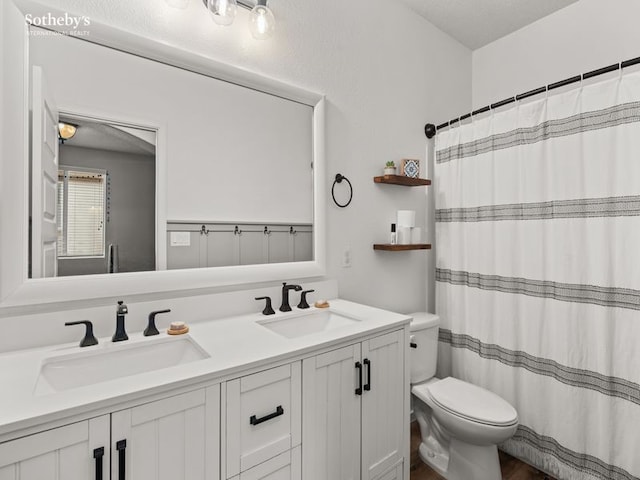 full bath featuring a shower with curtain, double vanity, toilet, and a sink