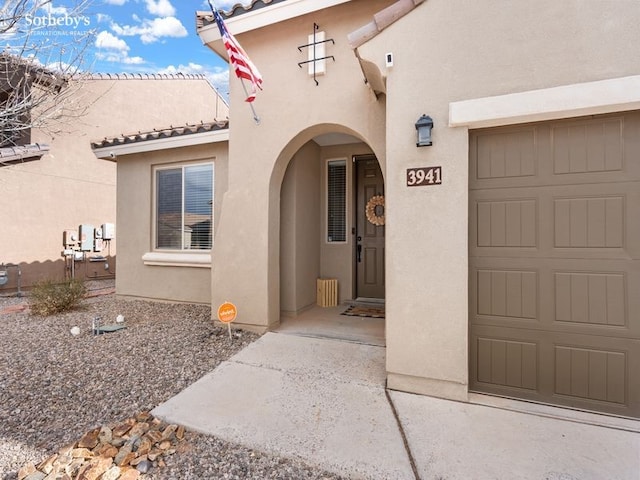 property entrance with stucco siding and a tiled roof