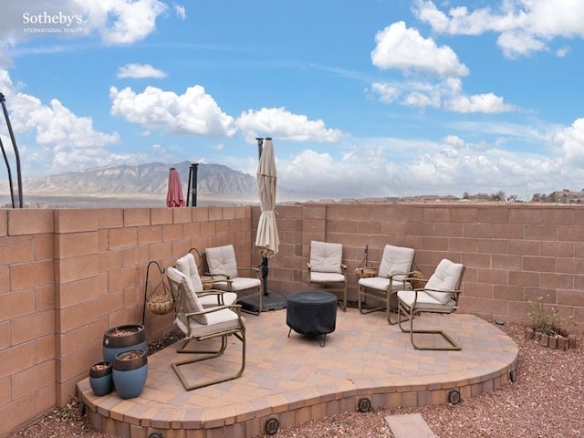 view of patio / terrace with a mountain view and a fenced backyard