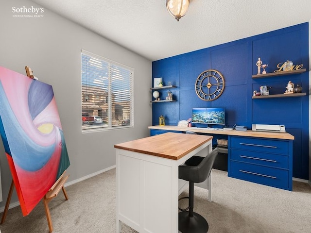 office area featuring light colored carpet, baseboards, and a textured ceiling