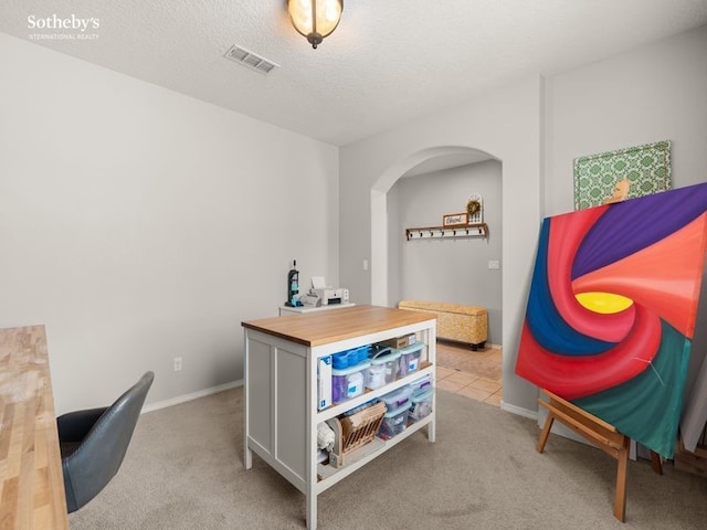 office space with baseboards, visible vents, carpet floors, and a textured ceiling