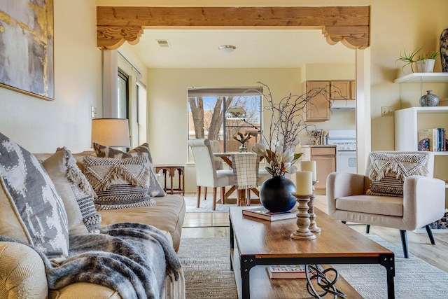 living area featuring visible vents and beamed ceiling