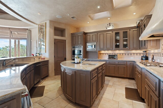 kitchen with a sink, visible vents, custom exhaust hood, and appliances with stainless steel finishes