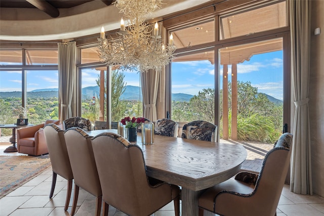 dining room with light tile patterned floors, a notable chandelier, and a mountain view