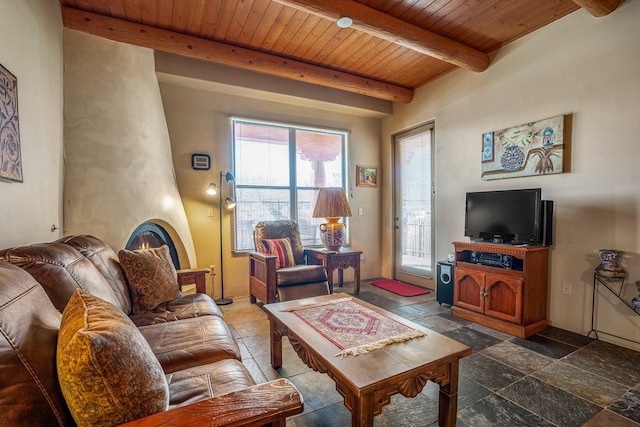 living room featuring stone tile flooring, beamed ceiling, wooden ceiling, and a large fireplace