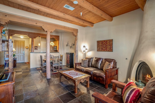 living room featuring visible vents, beam ceiling, stone tile flooring, wooden ceiling, and ornate columns