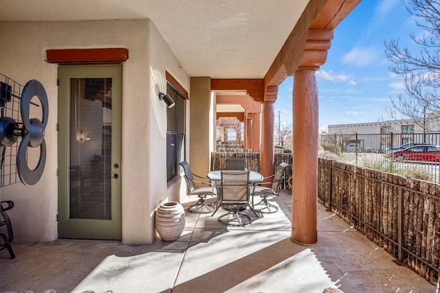 view of patio with outdoor dining space and fence