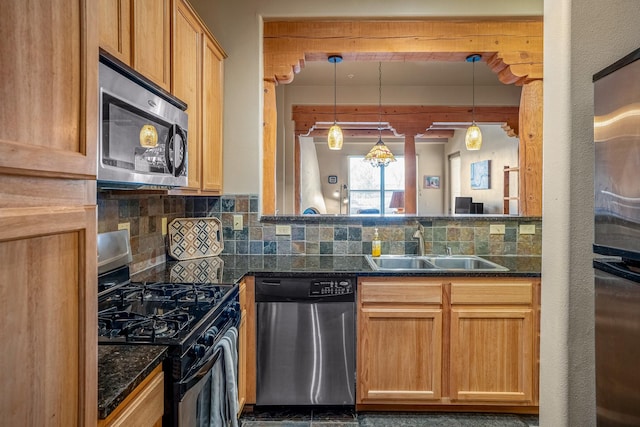 kitchen with a sink, hanging light fixtures, tasteful backsplash, and stainless steel appliances