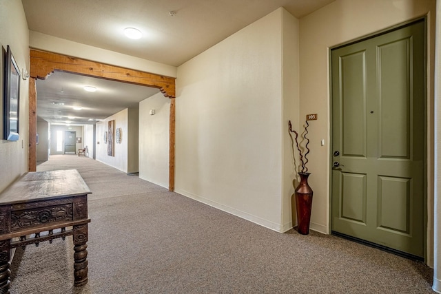 hallway with baseboards and carpet