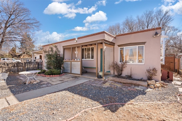 view of front of home with a gate, fence, and stucco siding