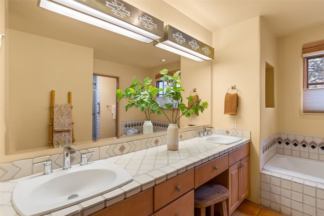 bathroom with double vanity, a bath, and a sink