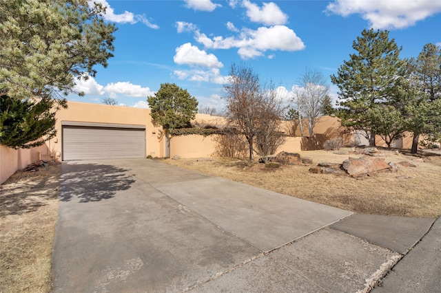 view of yard featuring concrete driveway, a garage, and fence