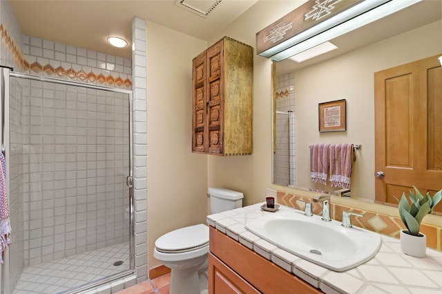 bathroom featuring tile patterned floors, toilet, a stall shower, and vanity