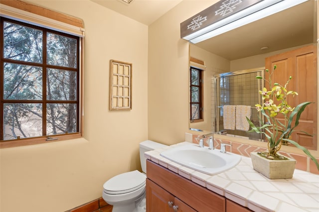 full bath featuring a stall shower, toilet, and vanity