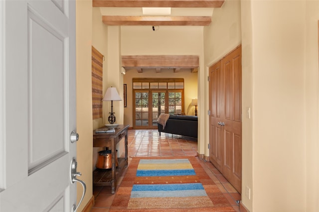 hallway featuring light tile patterned floors, beamed ceiling, and french doors