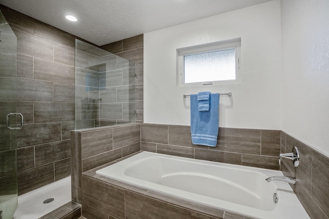 full bath with a shower stall, a garden tub, and a textured ceiling