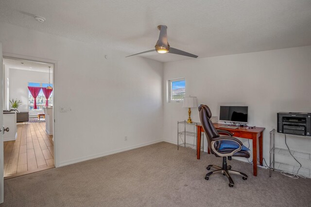 carpeted office space with a healthy amount of sunlight, baseboards, and ceiling fan