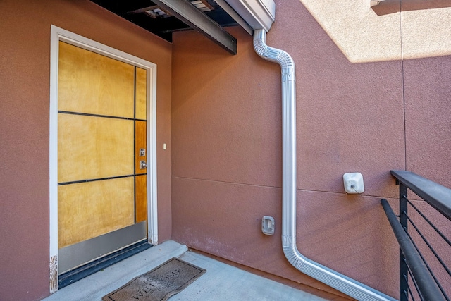 doorway to property featuring stucco siding