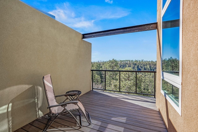 balcony featuring a forest view