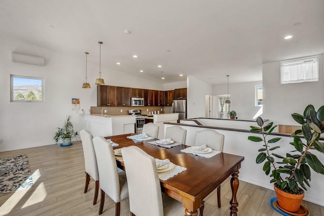 dining room with plenty of natural light, recessed lighting, light wood-style floors, and a wall unit AC