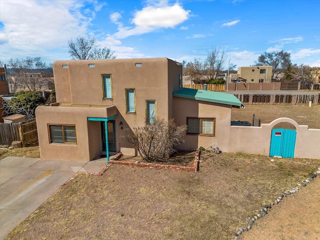 view of front of home with a fenced front yard and stucco siding