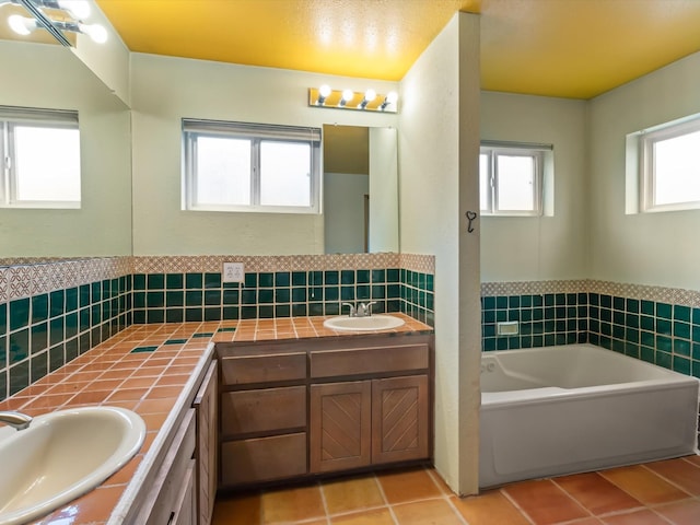 full bathroom with tile patterned flooring, double vanity, a bath, and a sink