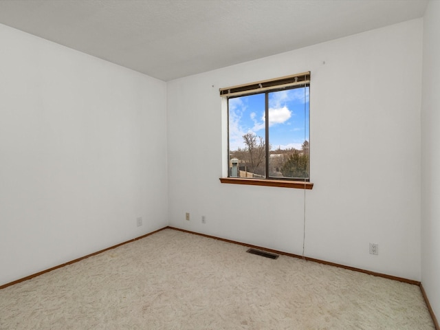 spare room featuring visible vents, carpet flooring, and baseboards