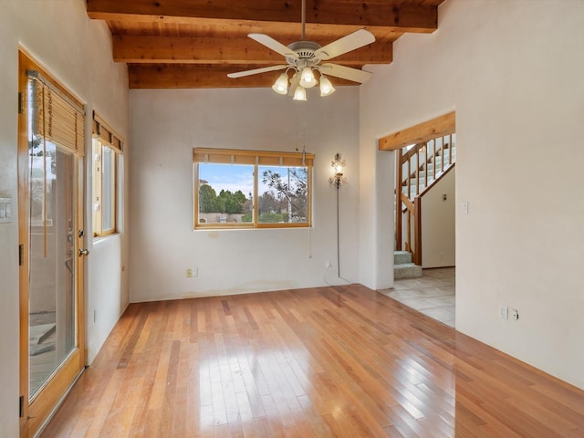 interior space featuring stairway, beamed ceiling, light wood-type flooring, and ceiling fan