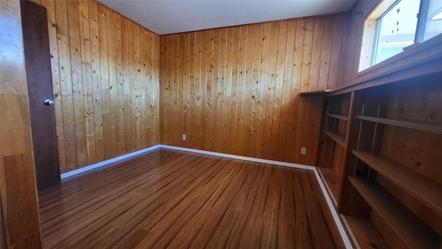 empty room with baseboards and wood finished floors