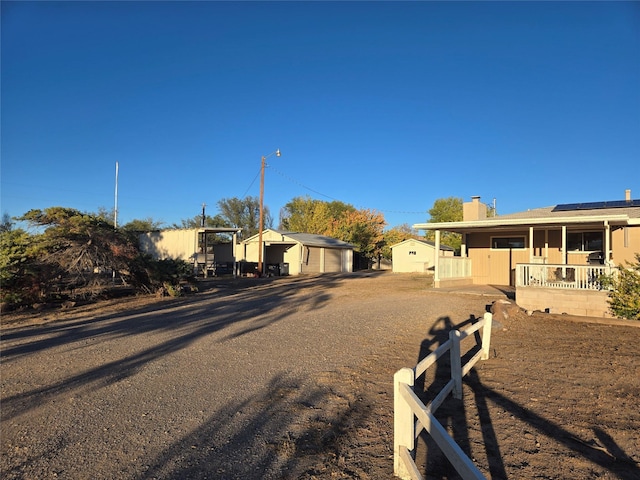 view of front of property featuring solar panels, a chimney, and fence