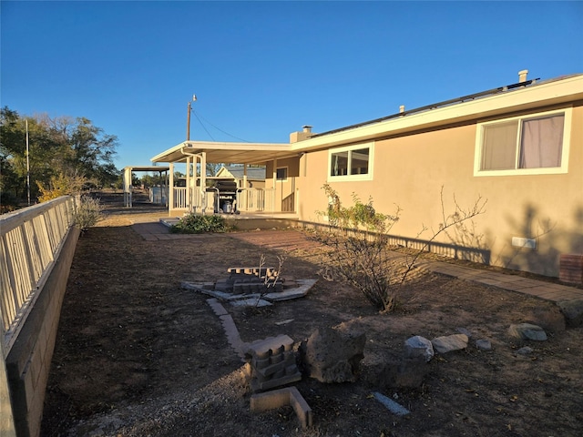 back of house featuring stucco siding and a fenced backyard