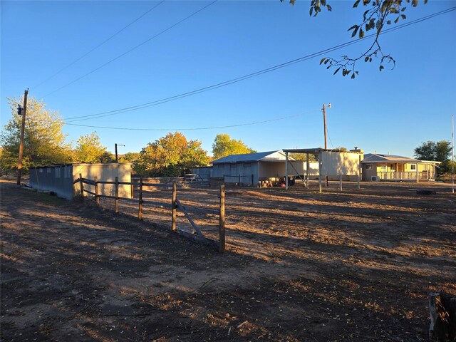 view of yard featuring an outbuilding, a pole building, and fence