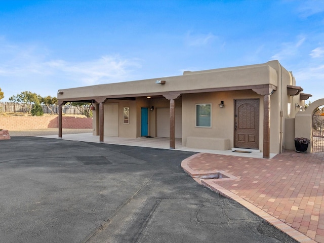 adobe home featuring fence and stucco siding