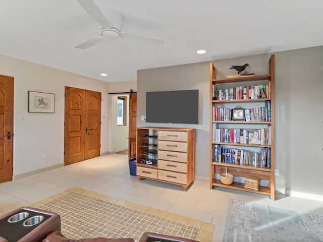 living area featuring recessed lighting, a barn door, light tile patterned flooring, baseboards, and ceiling fan