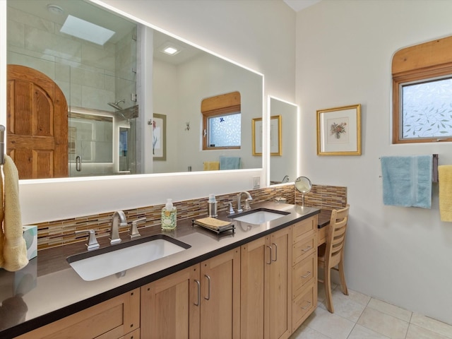 bathroom featuring tile patterned flooring, a shower stall, double vanity, and a sink