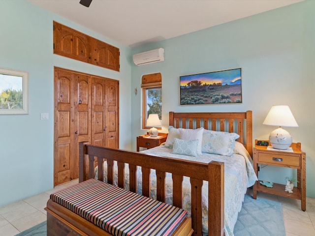 bedroom featuring light tile patterned floors, a closet, and a wall mounted AC