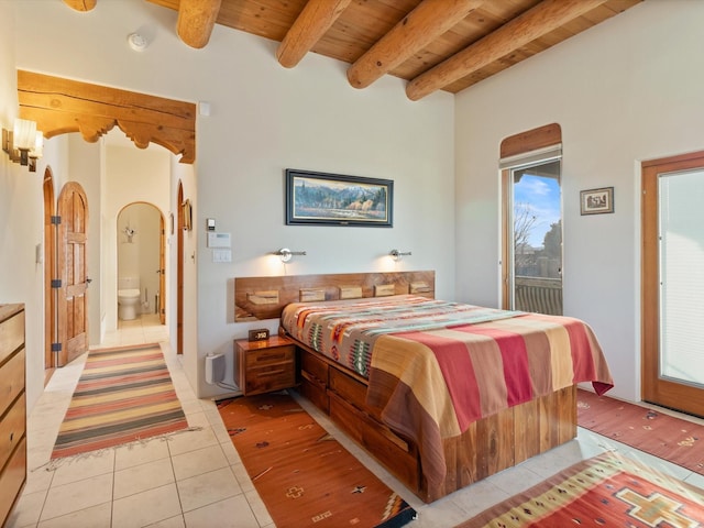 bedroom featuring light tile patterned flooring, access to exterior, ensuite bathroom, wooden ceiling, and beamed ceiling