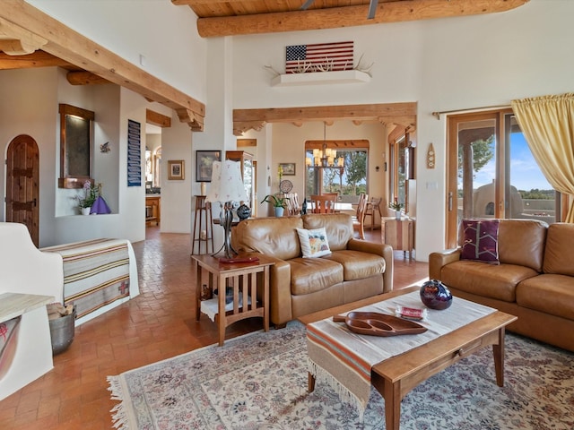 living room featuring beamed ceiling, a notable chandelier, wood ceiling, and a healthy amount of sunlight