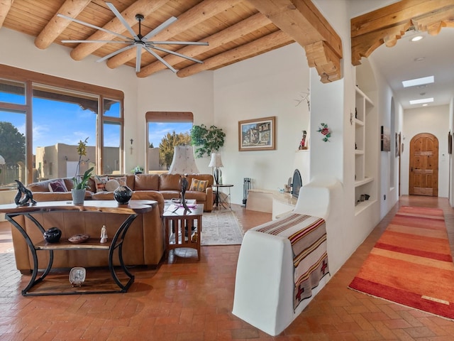 living area with beam ceiling, brick floor, wood ceiling, and arched walkways