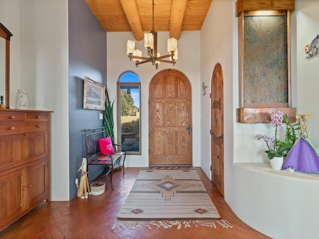 foyer entrance with wooden ceiling, beamed ceiling, brick floor, and a chandelier