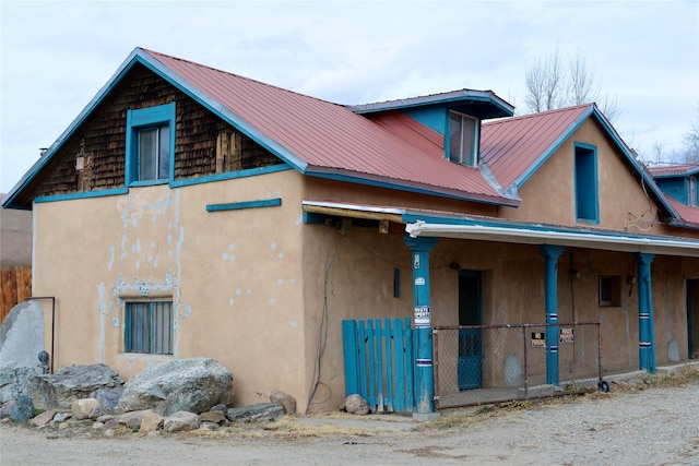 exterior space with stucco siding and metal roof