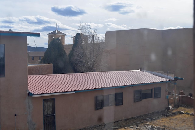 view of property exterior with stucco siding and metal roof