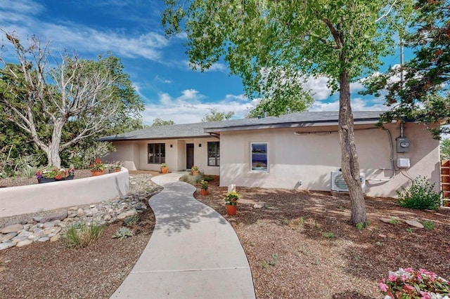 ranch-style home featuring stucco siding