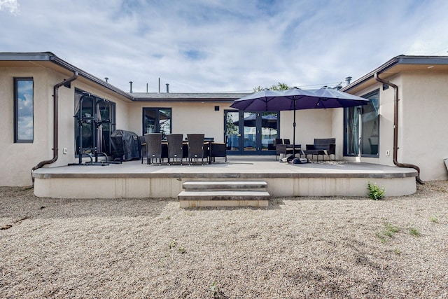 rear view of property with stucco siding and a patio area